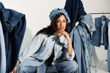 Genç kadın, renkli mevsimlik kıyafet sergileri arasında eşsiz kot elbisesiyle büyüleniyor..