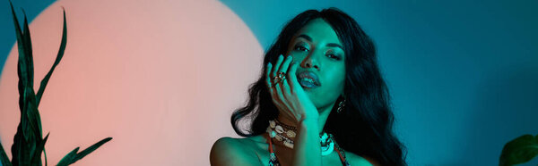 A stunning young woman poses gracefully, surrounded by a blend of colors that evoke summer vibes.