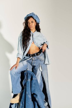 Genç bir kadın eşsiz kot tarzını sergilerken zarafet ve moda çekiciliği sergiliyor..