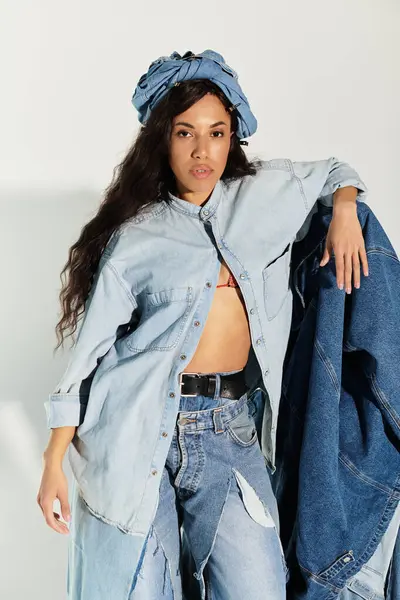 Genç bir kadın kendine güvenerek kendine has bir kot elbise sergiliyor..