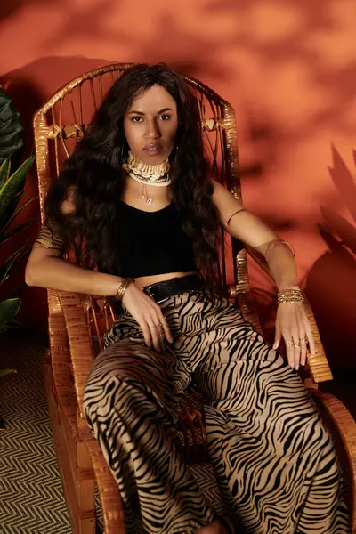 Genç bir kadın şık bir hasır sandalyede gevşeyip yaz modasını gösteriyor..