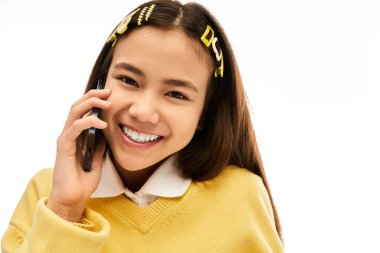 Şık üniformalı neşeli bir liseli kız telefonunda sohbet ediyor, gençliği ve yeteneği vurguluyor..