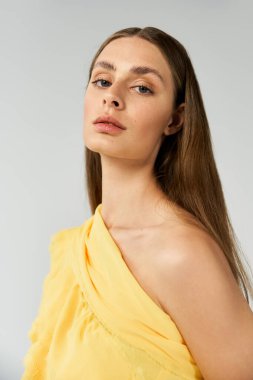 Göz kamaştırıcı bir kadın zarif yaz kıyafetlerini yumuşak sarı tonlarda sergiliyor..