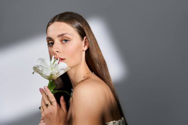 Zarif genç bir kadın narin bir çiçek tutar, büyüleyici ve zarif..