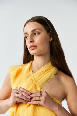 Hoş, genç bir kadın, sakin bir ifadeyle, şık, sarı bir yaz elbisesiyle....