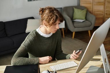 Çocuk, evdeki derslerine dalmış bir masada otururken mobil bir cihazla meşgul oluyor..