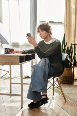 Öğrenci, sakin bir ev çalışma alanında akıllı telefonla iletişim kurar, odaklanma ve rahatlamayı birleştirir.