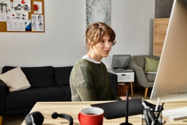 Bir adam sıcak ve davetkar bir ev atmosferiyle çevrili bir masada işine konsantre olur..