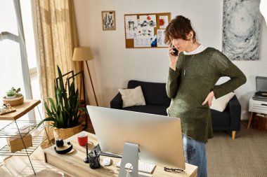 Genç bir öğrenci, rahat bir odada masasında ders çalışırken telefonla konuşuyor..