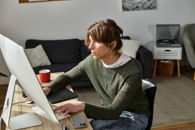 Rahat bir atmosfer ve modern dekorla çevrili, özenle evde çalışan genç bir adam..