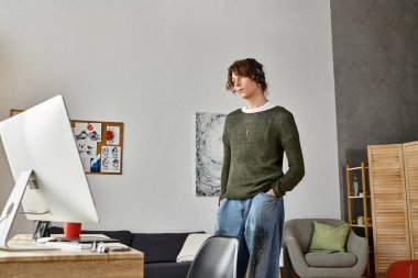 Genç bir adam düşünceli bir şekilde masasında duruyor, rahat evinde ders çalışıyor..