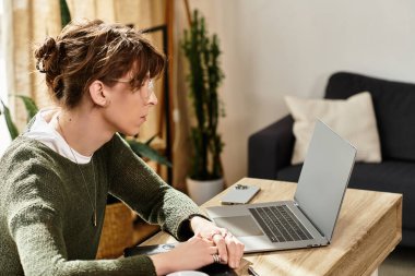 Huzurlu bir çevreyle çevrili, evde akademik işler yapan konsantre genç bir adam..