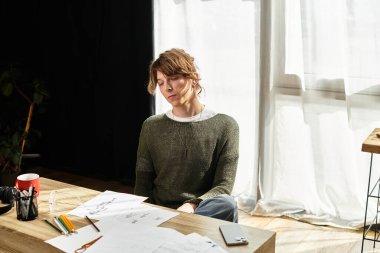 Genç öğrenci sanatsal eskizler ve notlar üzerinde çalışırken kendini evde çalışmaya verdi..