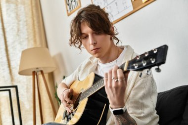Evde gitar çalan bir adam, sanatsal bir ifade anını vurguluyor..