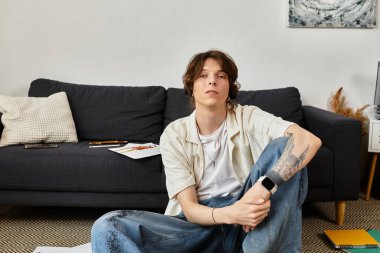 Genç bir adam sanatsal malzemeler ve konforla çevrili evde eğitim faaliyetlerine katılıyor..