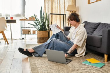 Genç bir adam evde çalışıyor, müziğe dalmış ve etrafı konfor ve ilhamla çevrili..