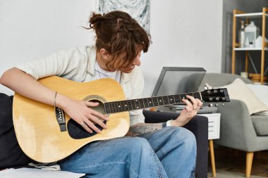 Evde bir adam gitarını çalıyor, müzik ve yaratıcılığa dalmış..