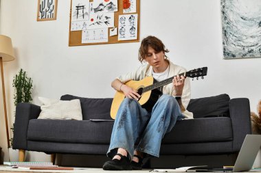 Genç bir adam rahat bir oturma odasında oturur gitar çalar ve kendini müziğe kaptırır..