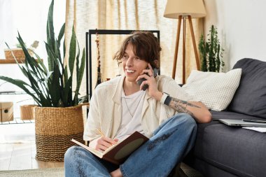 Genç bir öğrenci evde dinleniyor, telefonda sohbet ediyor ve fikirleri not defterine not alıyor..