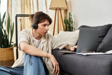 Genç bir öğrenci, bitkilerle çevrili rahat bir atmosferle çevrimiçi olarak evde öğrenim görüyor..