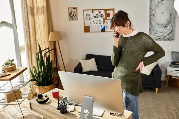 Genç bir öğrenci, rahat bir odada masasında ders çalışırken telefonla konuşuyor..