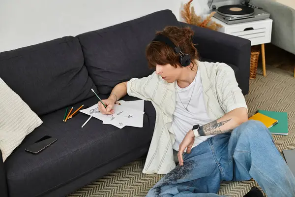 Nişanlı genç adam evde fikirler çiziyor, arka planda çalan müzikle sanat yaratıyor..