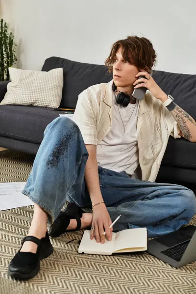 Öğrenci yerde oturur, öğrenme odaklıyken defter ve telefonla birden fazla iş yapar..