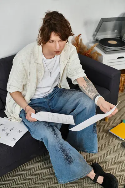 Odaklanmış öğrenci, rahat bir atmosferde rahat bir ev ortamı ile çevrili kağıtları inceliyor..