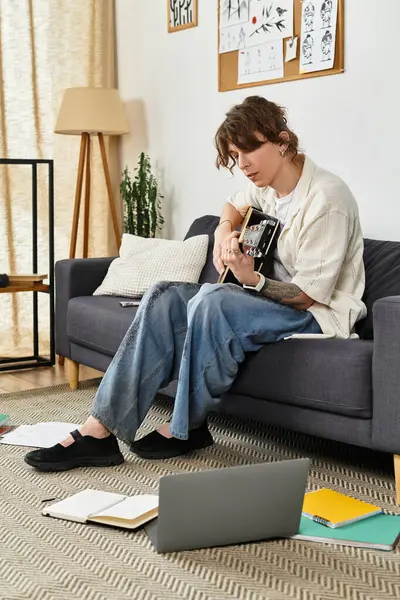 Genç bir öğrenci evde dinleniyor, bir gitar eşliğinde çalışmalar yapıyor..