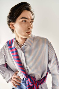 İkili olmayan genç bir kişi benzersiz moda anlayışını çağdaş bir arka planda sergiliyor..