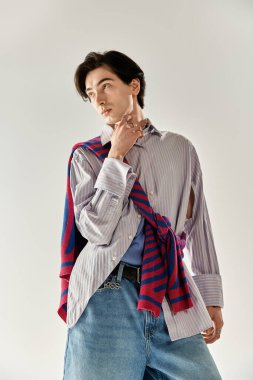 Şık, genç, ikili olmayan bir kişi kendine güvenerek, canlı moda tercihlerini ifade eder..