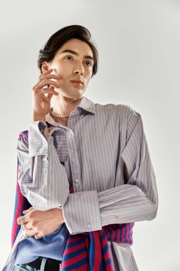 Genç, ikili olmayan birey, kapalı mekanda şık bir duruş sergiledi..