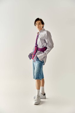 Kendine güveni tam genç bir birey modayı somutlaştıran modaya uygun bir kıyafet içinde duruyor..