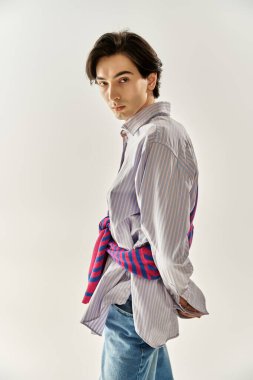 İkili olmayan genç bir insan şık görünümünü parlak, minimalist bir stüdyoda sergiliyor..