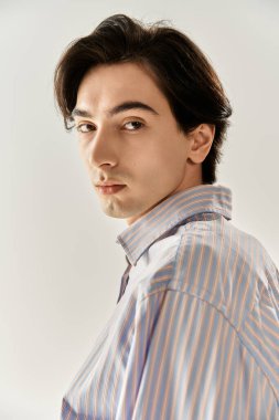 Genç, stil sahibi, ikili olmayan bir birey özgüven içinde duruyor ve benzersiz kimliklerini ifade ediyor..