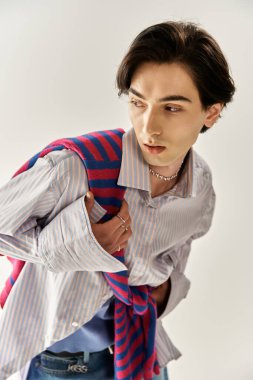 İkili olmayan birey, içeride güven ve yaratıcılıkla poz verirken şık kıyafetler giyer..