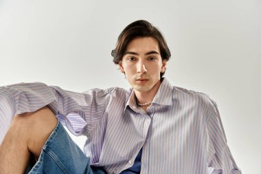 İkili olmayan genç bir kişi, benzersiz tarzını moda bir ortamda sergiliyor ve bireyselliği kucaklıyor..