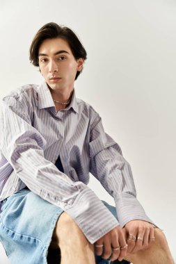 Şık, genç, ikili olmayan bir kişi sanatsal pozlar verirken canlı moda anlayışını sergiliyor..