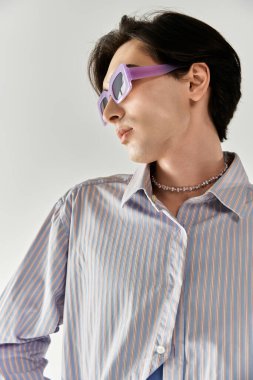 Genç ikili olmayan kişi moda ve benzersiz aksesuarlarla kimliğini ifade ediyor..