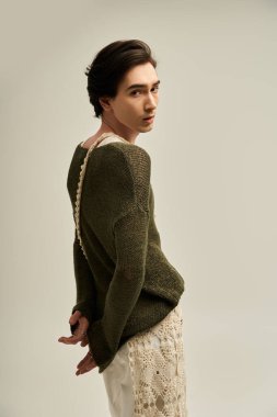 İkili olmayan genç bir birey cesur bir moda seçimi sergiliyor, kimliklerini güvenle ifade ediyor..