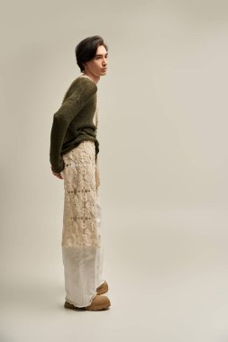 Tarz sahibi, genç, ikiz olmayan bir insan, kendine güvenen ve gururlu bir şekilde yaratıcı bir elbisenin içinde duruyor..