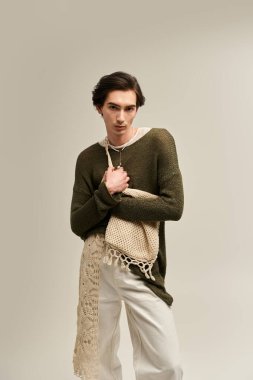 İkili olmayan şık bir kişi stüdyoda poz verir ve benzersiz kimliğini gösterir..