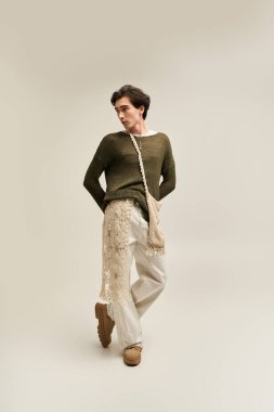 İkili olmayan genç bir kişi şık bir iç mekanda moda bir kıyafet sergiliyor, kimliğini kutluyor..