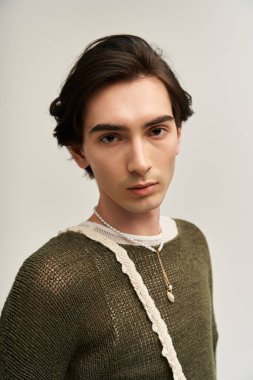 İkili olmayan genç bir insan, kendine güvenen minimalist bir ortamda eşsiz tarzını sergiliyor..