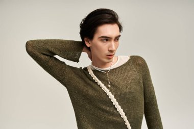 İkili olmayan genç bir kişi zarif bir şekilde modaya uygun bir şekilde poz verir ve kimliğini gösterir..