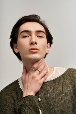 Şık, genç, çift kişilikli olmayan bir kişi şık görünümünü bir stüdyoya güvenerek sergiliyor..