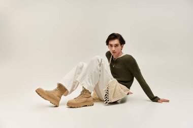 Bir stüdyoda zarif bir şekilde otururken eşsiz bir moda yeteneği sergiliyor..