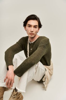 Genç ikili olmayan birey, şık kıyafetler ve kendine güvenen pozlarla kimliğini ifade eder..