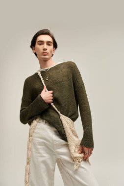 İkili olmayan bir birey, bir stüdyoda şık bir kıyafetle kimliklerini sergiliyor..