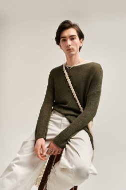 Moda düşkünü genç, ikili olmayan bireyler tarafsız bir arkaplana karşı güvenle dururlar..